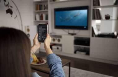 Apps para upnp e dlna - imagem de jovem usando celular como controle de TV